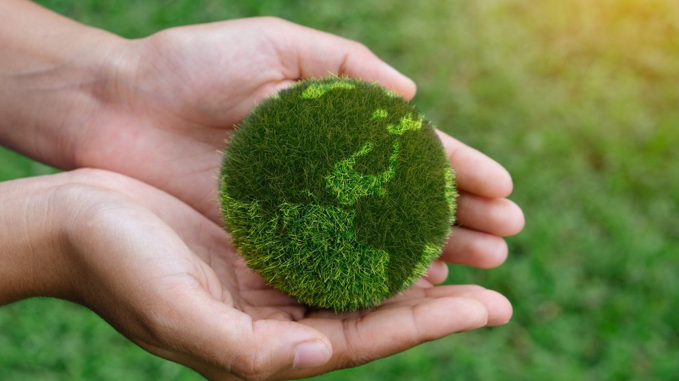 Hände halten grünes Modell der Erde
